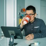 Monitor Overclocking - man in black and white checkered dress shirt drinking from brown and white ceramic mug