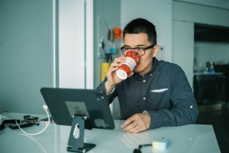 Monitor Overclocking - man in black and white checkered dress shirt drinking from brown and white ceramic mug