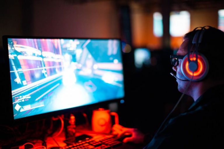 Game Development - person using computer playing FPS game
