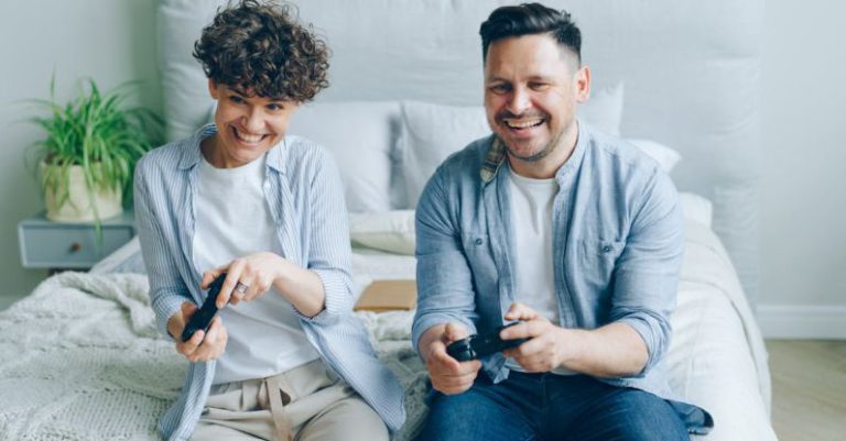 Antivirus Gaming - Two people sitting on a bed playing video games