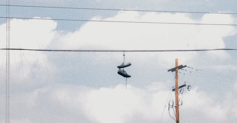 Aesthetic Build - Pair of Shoes Hanging on Electric Wire