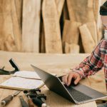 Tools Technology - Man Using a Laptop at a Wood Workshop