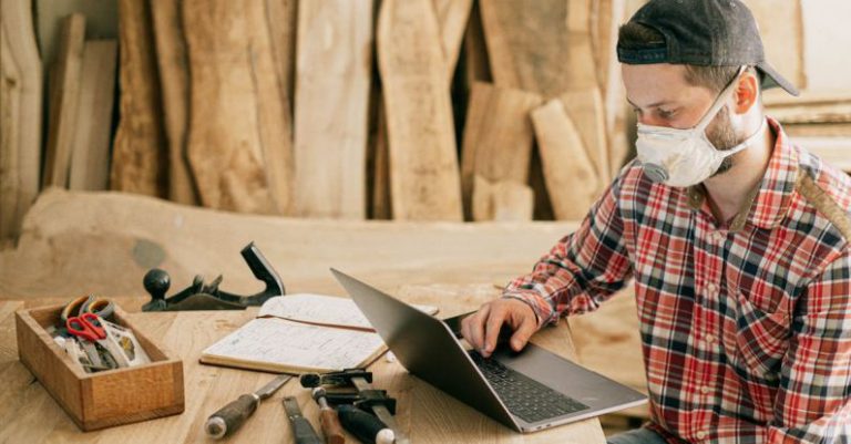 Tools Technology - Man Using a Laptop at a Wood Workshop