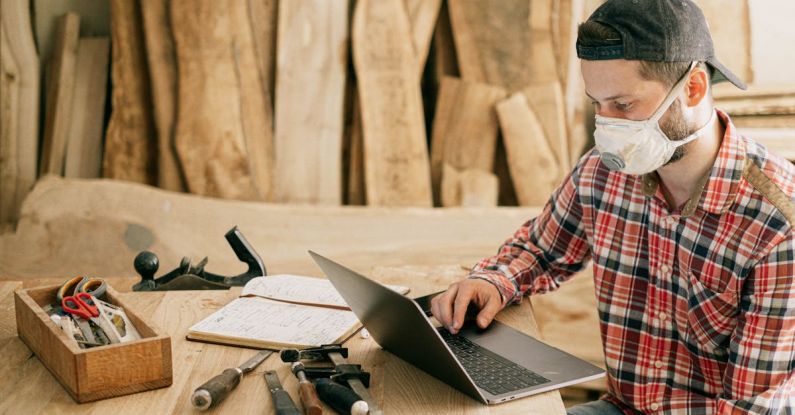 Tools Technology - Man Using a Laptop at a Wood Workshop