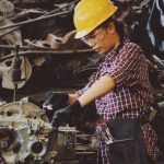 Overheating Fix - Woman Wears Yellow Hard Hat Holding Vehicle Part