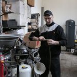 BIOS Troubleshooting - Focused mechanic repairing compressor hose in workshop
