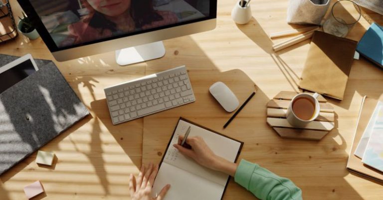 School PC - Person Writing on Notebook