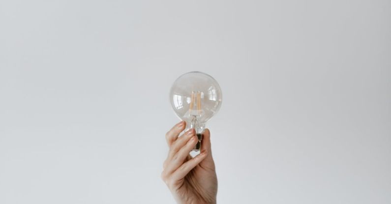 Efficient Power - Anonymous female showing light bulb