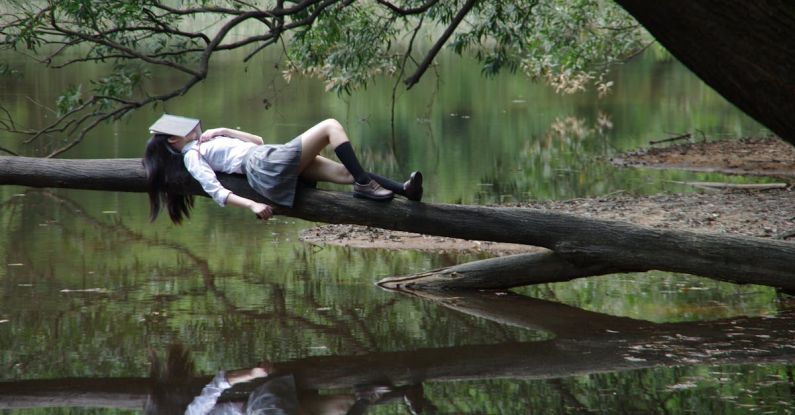 Water-cooled Dream - Woman Lying on Tree Near Awter